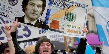 Javier Milei y un dólar con su cara. (AP)