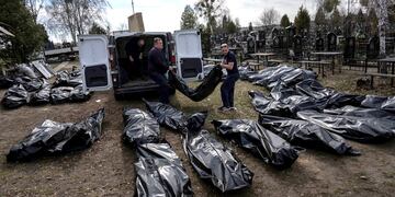 Trabajadores del cementerio descargan los cuerpos de los civiles asesinados desde una camioneta en el cementerio de Bucha, en las afueras de Kiev.