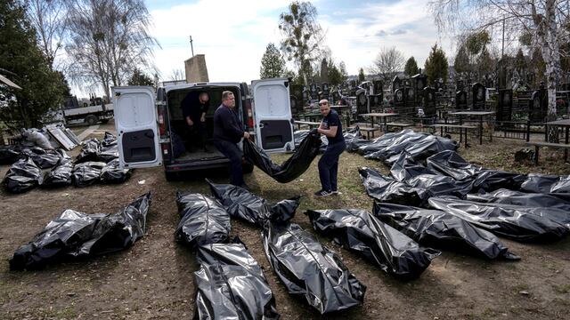 Trabajadores del cementerio descargan los cuerpos de los civiles asesinados desde una camioneta en el cementerio de Bucha, en las afueras de Kiev.