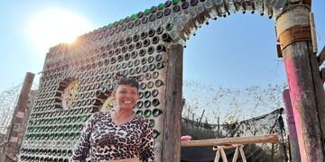Flavia construye su "casita de té" con botellas de vidrio.