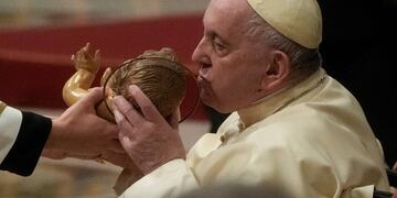 El Papa Francisco besa una estatua del Niño Jesús mientras preside la Misa de Nochebuena, en la Basílica de San Pedro en el Vaticano, el sábado 24 de diciembre de 2022 (imagen de archivo). Foto: AP/Gregorio Borgia
