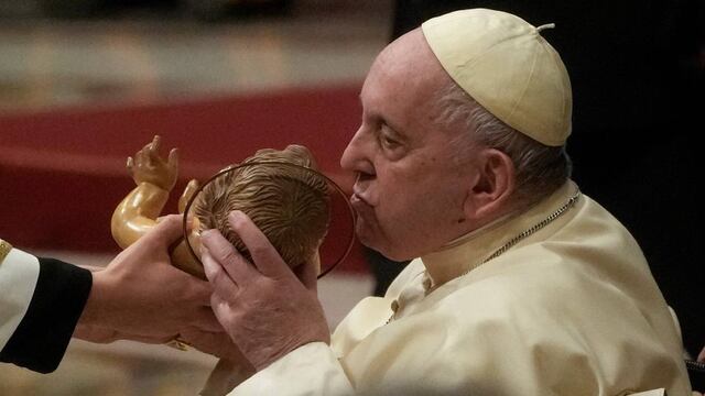 El Papa Francisco besa una estatua del Niño Jesús mientras preside la Misa de Nochebuena, en la Basílica de San Pedro en el Vaticano, el sábado 24 de diciembre de 2022 (imagen de archivo). Foto: AP/Gregorio Borgia