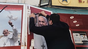 Un propietario de una tienda coloca un lazo negro sobre una foto del fallecido papa Francisco al conocer la noticia de su muerte a los 88 años, en Belén, Cisjordania, el lunes 21 de abril de 2025. (AP Foto/Mahmoud Illean)