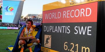 Armand Duplantis, enfundado en los colores de su país, muestra orgulloso el récord mundial de salto con garrocha que estableció en Eugene. (AP)