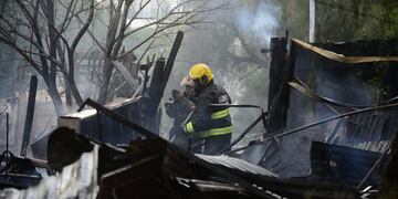 Incendio tragico en Villa La Tablita. Policia judicial trabaja en el lugar mientras el intendente Martin Llaryora recorre el lugar. Foto José Hernandez / La Voz