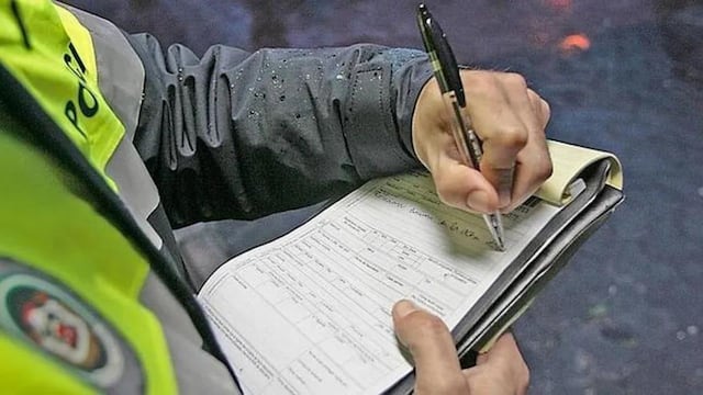 Autoridades anotando infracciones de tránsito.