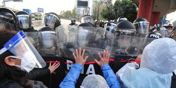 Trabajadores de la salud chocan con efectivos de la Prefectura al querer marchar sobre el puente Pueyrredón.
