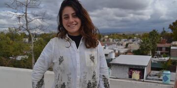 Agostina Andrada creadora del emprendimiento. Viste una camisa estampada con jarilla.