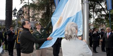 El concejal Lisandro Aguiar, el principal Gonzalo Rosalé y la contadora Virginia Llapur izaron la Bandera Nacional en uno de los mástiles ubicados al pie del monumento al General Belgrano.