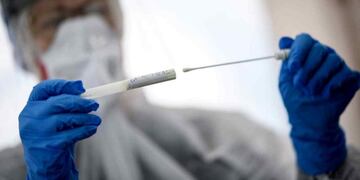 Un trabajador de la salud sostiene un hisopado de coronavirus (Archivo).