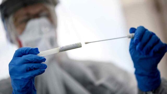 Un trabajador de la salud sostiene un hisopado de coronavirus (Archivo).