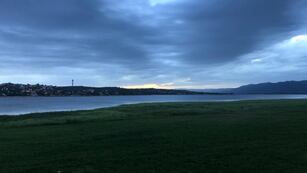 Carlos Paz, costanera del Lago San Roque, atardecer "mayormente nublado".