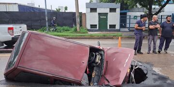 El auto que fue "tragado" por un socavón en plena Vélez Sársfield, una de las principales avenidas de la Capital cordobesa. (Nicolas Bravo/La Voz)