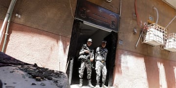 Dos agentes vigilan la entrada de la iglesia de Abu Sefein, donde se ha producido el incendio.