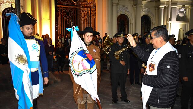 El padre Manuel Alfaro bendice las Banderas Nacional y de la Libertad Civil, en el atrio de la Iglesia Catedral, en el casco histórico de San Salvador de Jujuy.
