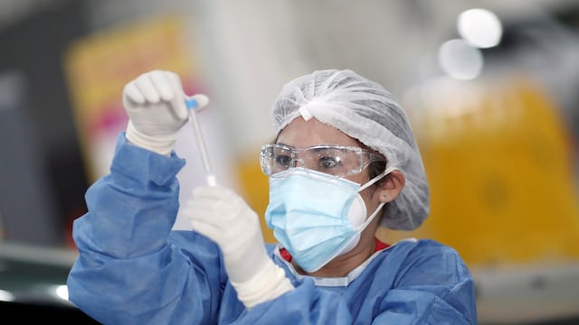Una trabajadora de la salud sostiene un hisopado de coronavirus. (Foto: Agustin Marcarian)