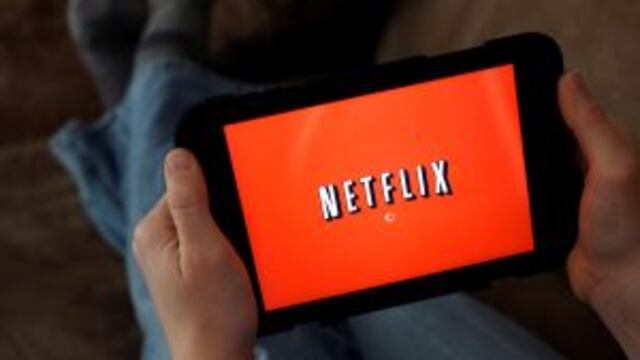 FILE - In this Friday, Jan. 17, 2014, file photo, a person displays Netflix on a tablet in North Andover, Mass. Netflix subscribers can now download shows and movies to watch later when theyu2019re not online, like during a flight or car. The download option