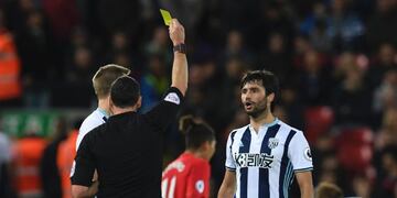 West Bromwich Albion's Argentinian midfielder Claudio Yacob (R) is shown a yellow card by referee Neil Swarbrick (L) during the English Premier League football match between Liverpool and West Bromwich Albion at Anfield in Liverpool, north west England on September 10, 2016\u002E / AFP PHOTO / PAUL ELLIS / RESTRICTED TO EDITORIAL USE\u002E No use with unauthorized audio, video, data, fixture lists, club/league logos or 'live' services\u002E Online in-match use limited to 75 images, no video emulation\u002E No use in betting, games or single club/league/player publications\u002E / inglaterra liverpool Claudio Yacob futbol campeonato de primera division de inglaterra futbolistas partido Liverpool vs West Bromwich Albion