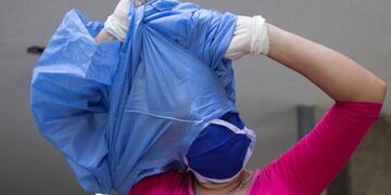 A woman who cares for a hospitalized relative removes her protective medical gear after leaving the COVID-19 wing of the José Gregorio Hernández Hospital, a public hospital in the Catia neighborhood of Caracas, Venezuela, Thursday, Sept\u002E 24, 2020\u002E In recent years, an estimated 5 million Venezuelans have fled the nation of 30 million, among them roughly 33,000 doctors, or 30% of Venezuela’s physicians, according to Dr\u002E Douglas León Natera, president of the Federation of Venezuelan Doctors\u002E (AP Photo/Ariana Cubillos)