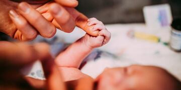 Cecile Eledge se ofreció como vientre subrogado para que su hijo y su pareja pudieran ser padres Elliott Dougherty and Matthew Eledge's daughter Uma grasps a finger shortly after Matthew's mother Cecile, gave birth at the University of Nebraska Medical Center in Omaha, Nebraska, U\u002ES\u002E, March 25, 2019\u002E     Picture taken March 25, 2019\u002E     REUTERS/Ariel Panowicz / @arielpanowicz   MANDATORY CREDIT eeuu  mujer de 61 años da a luz al bebe de su hijo gay madre y abuela a la vez gesto para ayudar a su hijo y a su marido a formar una familia
