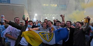 Leeds United supporters gather outside their Elland Road ground to celebrate the club's return to the Premier League after a gap of 16 years, in Leeds, northern England on July 17, 2020\u002E - Leeds United were promoted to the Premier League on Friday after West Bromwich Albion's 2-1 defeat at Huddersfield ensured the Championship leaders will end their 16-year exile from the top-flight\u002E (Photo by Paul ELLIS / AFP)