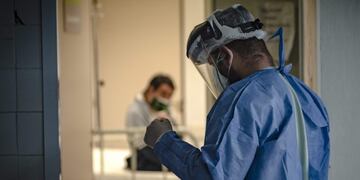 Dr Mario Grossmann wearing protective suit visits a patients with COVID-19, during his 24hs shift, at the emergency area of the Doctor Alberto Antranik Eurnekian Public Hospital in Ezeiza, in the outskirts of Buenos Aires on August 29, 2020, amid the new coronavirus, COVID-19, pandemic\u002E - Dr Grossmann, a professor, head of practical work of semiology and internal medicine at Buenos Aires University (UBA) and chair head of semiology and internal medicine at Universidad Abierta Interamericana (UAI) teaches from the hospital through video calls to students of 4th and 5th year\u002E (Photo by ARIEL TIMY TORRES / AFP)