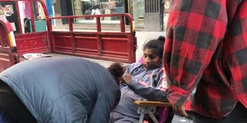 La suegra se prepara para pasarla a Marcela de la reposera a la silla de ruedas\u002E