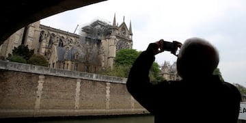 A man takes pictures of Notre-Dame Cathedral after a massive fire devastated large parts of the gothic gem in Paris, France April 16, 2019\u002E