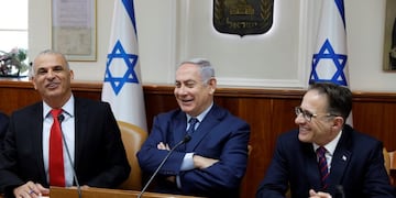 Israeli Prime Minister Benjamin Netanyahu, center, sits between Government secretary Braverman Tzachi, right, and Finance Minister Moshe Kahlon, at the start of the weekly cabinet meeting at the Prime Minister's office in Jerusalem, Sunday, April 15, 2018\u002E (Gali Tibbon/Pool via AP)
