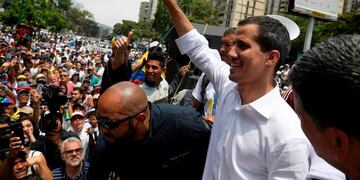 Venezuelan opposition leader Juan Guaido gestures at supporters during a rally to commemorate May Day on May 1, 2019 after a day of violent clashes on the streets of the capital spurred by his call on the military to rise up against President Nicolas Maduro\u002E - Guaido called for a massive May Day protest to increase the pressure on President Maduro\u002E (Photo by Federico PARRA / AFP)