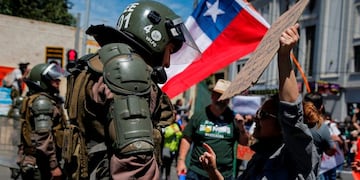 Un manifestante dialoga con un oficial de la policía antidisturbios en Valparaíso, Chile, el 22 de octubre de 2019, en el quinto día consecutivo de protestas contra una subida ahora suspendida en los precios de los boletos del metro\u002E Crédito: JAVIER TORRES / AFP\u002E
