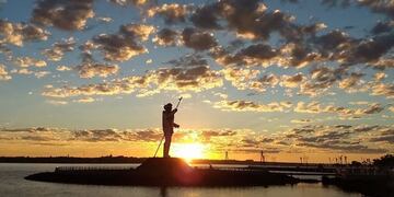 Amanece en Posadas y el sol se levanta del este por dertrás de la estatua a Andresito\u002E