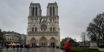 (FILES) In this file photo taken on March 29, 2018 a person walks in the rain in front of Notre-Dame de Paris Cathedral during the celebrations of Easter's Holy in Paris\u002E - A fire broke out at the landmark Notre-Dame Cathedral in central Paris on April 15, 2019 afternoon, potentially involving renovation works being carried out at the site, the fire service said\u002E (Photo by Ludovic MARIN / AFP)