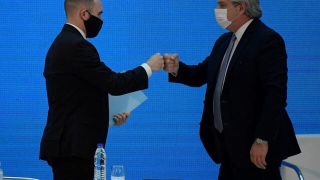 El presidente Alberto Fernández choca su puño con el ministro de Economía Martín Guzmán. (Juan Mabromata/Pool via AP)