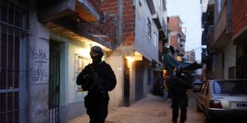 Argentine police officers patrol during a raid in search of illegal drugs, including the crack-like drug called