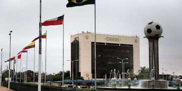 The flags of South America fly next to the South American soccer confederation, CONMEBOL, building in Luque, Paraguay, Tuesday, July 23, 2019\u002E CONMEBOL has removed Argentine Football Association president Claudio Tapia from his seat on the FIFA council with immediate affect\u002E Tapia was critical of the organisation in an open letter published during the Copa American earlier this month\u002E (AP Photo/Jorge Saenz)