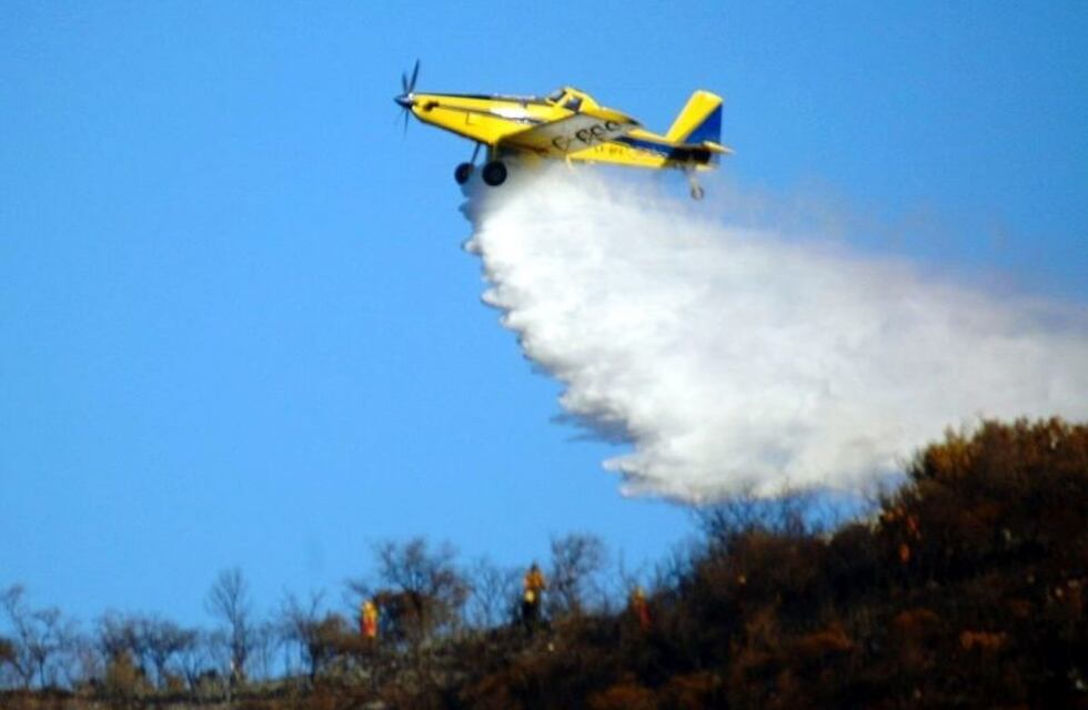 Bomberos luchan para apagar las llamas en un campo en La Calera