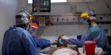 Dr\u002E Marcelo Moretti, right, adjusts a protective face mask on a COVID-19 patient inside the intensive care unit at the El Cruce Dr\u002E Nestor Carlos Kirchner Hospital, on the outskirts of Buenos Aires, Argentina, Tuesday, Sept\u002E 15, 2020\u002E Healthcare workers in Argentina warn that they are being pushed beyond their limits as they care for a growing number of new coronavirus patients with limited human resources as isolation measures are relaxed\u002E (AP Photo/Natacha Pisarenko)