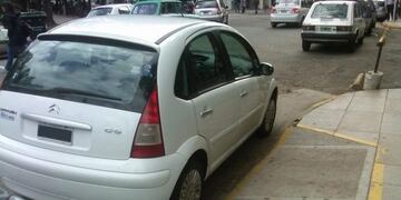 Auto estaciona sobre rampa para discapacitados