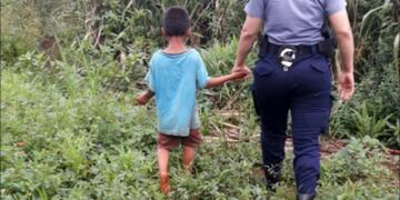 El niño es llevado de la mano por una agente de la Comisaría de la Mujer\u002E