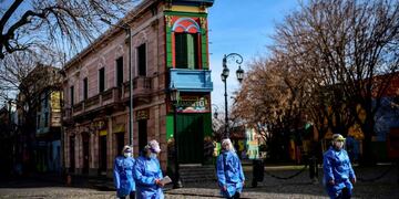 Women health workers walk at Caminito street after visiting people suspected of having COVID-19 at La Boca neighbourhood in Buenos Aires, on July 9, 2020 amid the new coronavirus pandemic\u002E - Buenos Aires' La Boca neighbourhood has been hit hard by the lack of tourists due to the pandemic\u002E (Photo by Ronaldo SCHEMIDT / AFP)