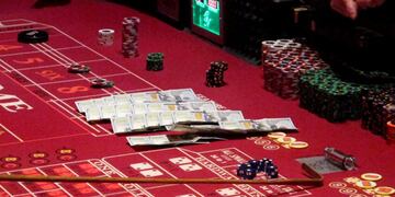 This June 24, 2016 photo shows cash, chips and dice on a craps table during a game at the Golden Nugget casino in Atlantic City, N\u002EJ\u002E On June 16, 2020, the American Gaming Association, the casino industry's national trade group, called on state gambling regulators to make it easier for gamblers to use cashless betting options during the coronavirus outbreak\u002E (AP Photo/Wayne Parry)