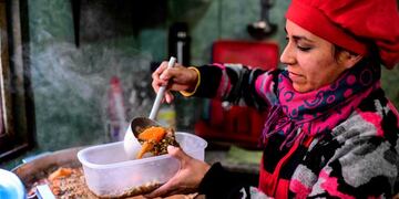 A woman serves food at a soup kitchen which feeds at least 200 people hit hard by the economic crisis, at the Villa 21-24 shantytown in Buenos Aires on September 3, 2019\u002E - After the bank run occured Monday with a depreciation of the peso of over 20%, price hikes are expected to impact Argentinians' pockets again\u002E (Photo by RONALDO SCHEMIDT / AFP)  POBREZA EMERGENCIA ALIMENTARIA - ALIMENTOS COMIDA  VILLA 21 24