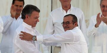 Colombiau2019s President Juan Manuel Santos, left, and the top commander of the Revolutionary Armed Forces of Colombia (FARC) Rodrigo Londono, known by the alias Timochenko, shake hands after signing a peace agreement between Colombiau2019s government and the FARC to end over 50 years of conflict in Cartagena, Colombia, Monday, Sept. 26, 2016. (AP Photo/Fernando Vergara)rn colombia cartagena Juan Manuel Santos Rodrigo Londou00f1o Echeverri colombia final del conflicto armado con las FARC el gobierno de colombia y las farc firman la paz firma definitiva acuerdo de paz