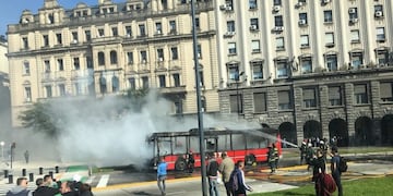 Los bomberos extinguen las llamas de un colectivo incendiado en Plaza de Mayo\u002E