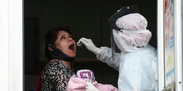 A medical staff member in protective suit takes a swab sample to test for the coronavirus disease (COVID-19), as part of the detectAR (detect) plan in Beccar, on the outskirts of Buenos Aires, Argentina June 17, 2020\u002E REUTERS/Agustin Marcarian