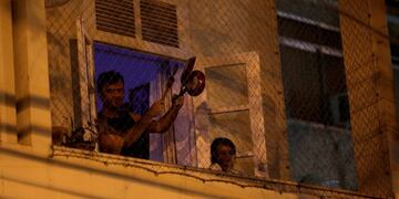 A man bangs a pot at the window of his house as he protests against Brazilian President Jair Bolsonaro during the coronavirus disease (COVID-19) outbreak in Rio de Janeiro, Brazil, March 18, 2020\u002E REUTERS/Ricardo Moraes