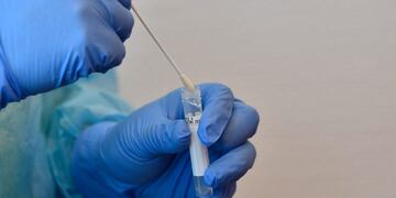 A health worker demonstrates how he does a test for the novel coronavirus COVID-19 at a test station at the Berlin-Schoenefeld airport in Berlin, on July 31, 2020\u002E - Germany will make coronavirus tests mandatory for travellers returning from at-risk areas, as fears grow over rising case numbers blamed on summer holidays and local outbreaks\u002E (Photo by Tobias Schwarz / AFP)