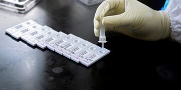 A health worker wearing a Personal Protective Equipment (PPE) suit tests a swab sample for the Covid-19 coronavirus at a primary health centre in Hyderabad on September 3, 2020\u002E (Photo by NOAH SEELAM / AFP)