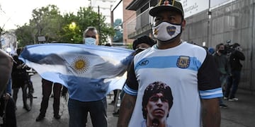 TOPSHOT - Supporters of Argentine former football star and coach of Gimnasia y Esgrima La Plata Diego Maradona gather outside the hospital where he will undergo brain surgery for a blood clot, in Olivos, Buenos Aires province, on November 3, 2020\u002E (Photo by JUAN MABROMATA / AFP)